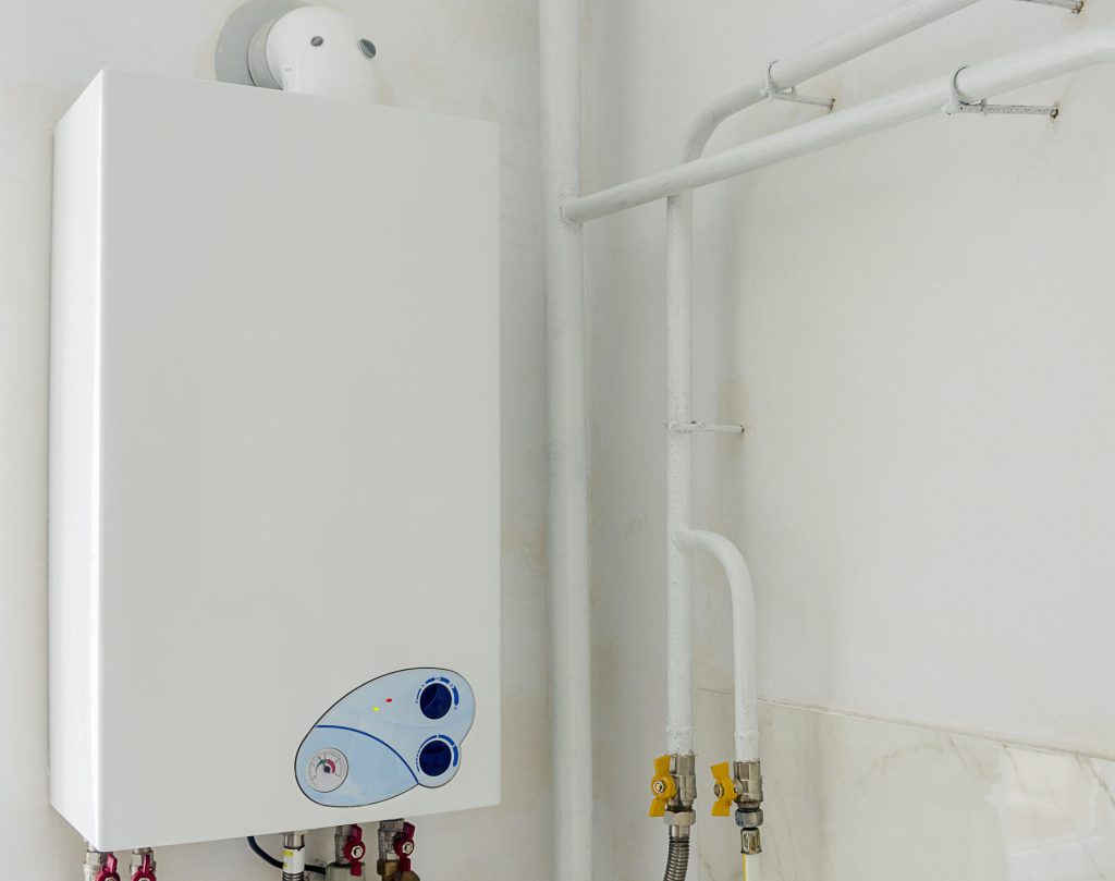 How Much is Central Heating - Image of a domestic boiler system on a wall with pipework showing